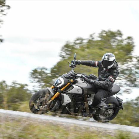 A black, white and gold 2019 Ducati Diavel 1260S being ridden on a country road